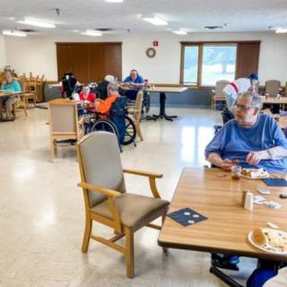 Elderly residents engaged in activities at a nursing home common area.