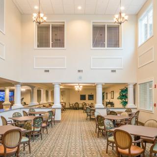 A spacious and well-lit dining area with tables, chairs, and chandeliers.