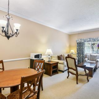 A cozy living and dining area with classic furnishings and warm lighting.