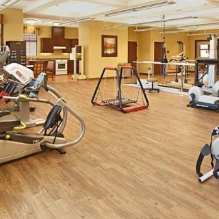 A well-equipped gym with various exercise machines and a spacious interior.