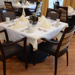 An elegantly set dining table with neatly arranged place settings in a restaurant.