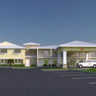 A hotel building with a parking lot and a vehicle parked outside.