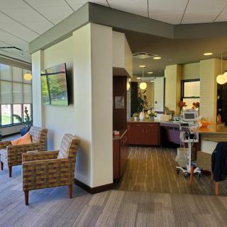 A hospital waiting area with chairs and medical equipment.