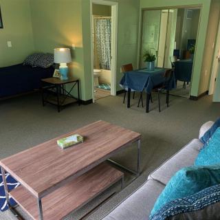 A cozy living room with a coffee table, sofa, and dining area.