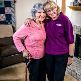 Two women sharing a joyful moment indoors, showcasing friendship and companionship.