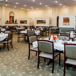 A spacious restaurant dining area with neatly arranged tables and chairs, showcasing elegant interior design.