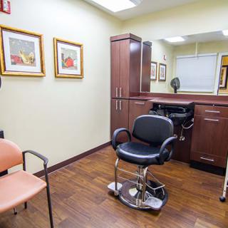 A modern hair salon interior with a barber chair and vibrant artwork on the walls.