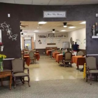 A well-arranged dining area with tables and chairs, featuring warm decor.