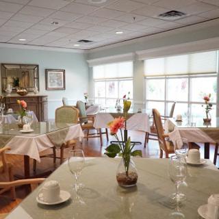 A serene dining area with elegantly set tables and floral arrangements.