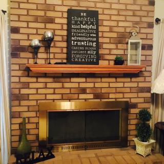 A cozy living room with a brick fireplace and decorative mantel.
