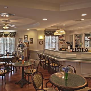 A cozy bistro interior with tables, chairs, and a bar counter.