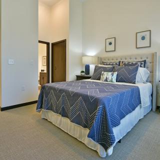 A cozy and stylishly decorated bedroom with a neatly made bed and soft lighting.