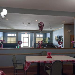 A decorated dining area with heart-themed decorations and balloons.