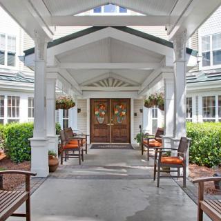 Front entrance of a building with outdoor seating and decorative landscaping.