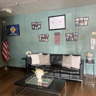 A welcoming lobby space featuring modern seating, decorative flags, and framed photographs.