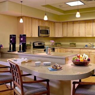 A modern kitchen with wooden cabinetry, stainless steel appliances, and a spacious countertop with seating.