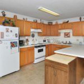A spacious kitchen featuring wooden cabinets and modern appliances.