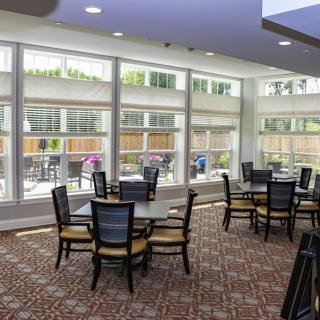 A modern dining area with large windows allowing natural light to fill the room.