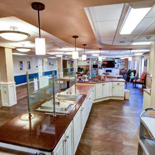A modern kitchen and dining area with sleek countertops and elegant lighting fixtures.