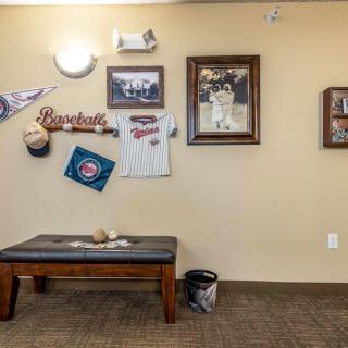A sports-themed room featuring baseball memorabilia and decor on the walls, accompanied by a wooden bench below.