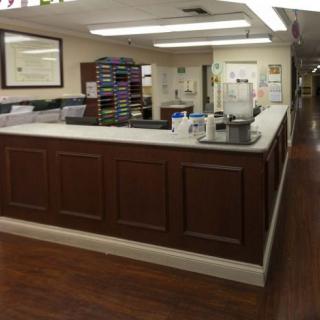 A hospital reception area with a desk and hallway.