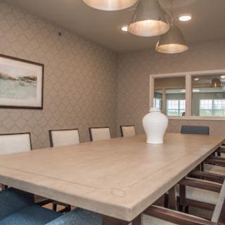 A stylish and modern dining room featuring a large wooden table, comfortable chairs, and contemporary lighting.