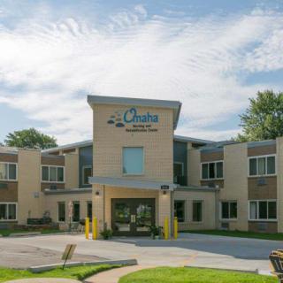 A modern clinic building with a welcoming entrance under a partly cloudy sky.