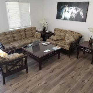 A cozy living room featuring a sofa set, coffee table, and decorative artwork on the wall.