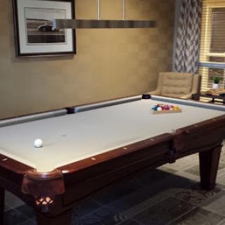 A stylish game room featuring a polished pool table ready for a match.