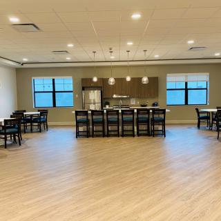 Modern dining and kitchen area with ample seating and natural lighting.