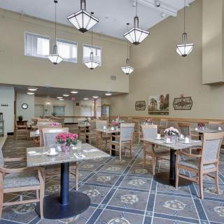 A spacious and well-lit dining area with neatly arranged tables and chairs.