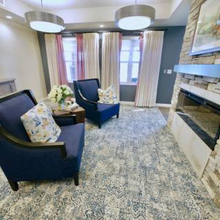 A cozy living room with modern blue chairs and a fireplace.