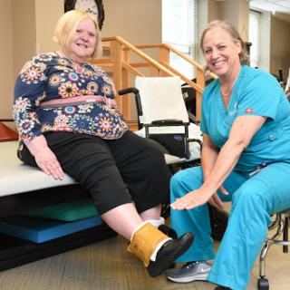 A patient receiving physical therapy support from a healthcare professional, highlighting the importance of rehabilitation.