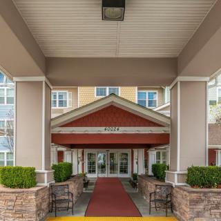 The entrance of a hotel with a red carpet and covered canopy.