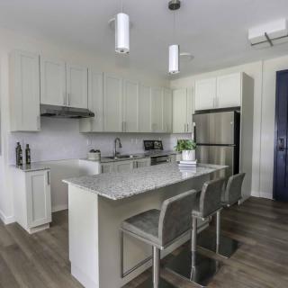 A modern kitchen with an island and stainless steel appliances.