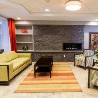 A modern living room with a sofa, armchair, coffee table, and fireplace.