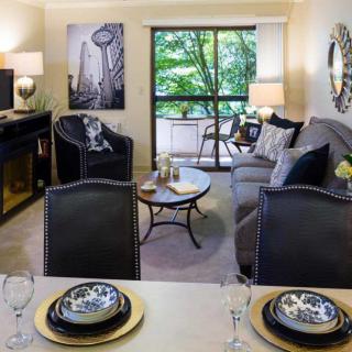 A modern living room with elegant decor, featuring a cozy seating area and dining space.