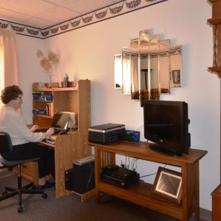 A person working at a computer desk in a home office setting.