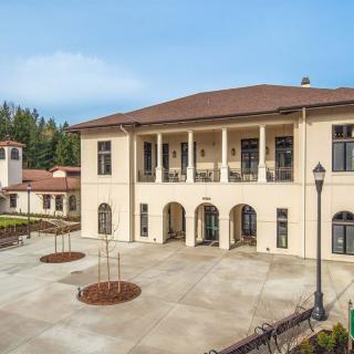 A large building with a courtyard, featuring columns and a balcony.