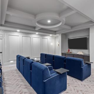 A modern home theater with blue seating and a large screen.