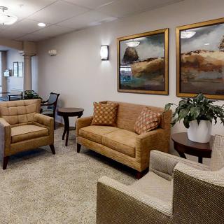 A cozy waiting room with comfortable seating and decorative artwork on the walls.