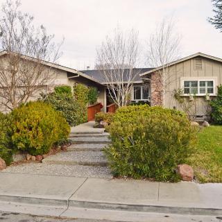 A suburban house with a landscaped front yard and pathway leading to the entrance.