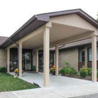 A building entrance with a covered canopy and landscaped surroundings.