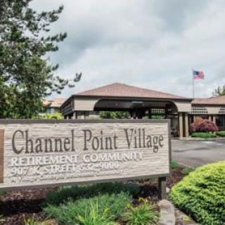Entrance to Channel Point Village Retirement Community with sign and landscaping.