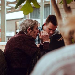 Two men engaged in a private conversation at a cafe.