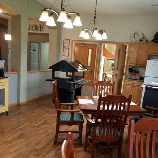A cozy kitchen and dining area with wooden furniture and elegant lighting.