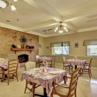 A cozy dining room with a brick fireplace and neatly arranged tables.