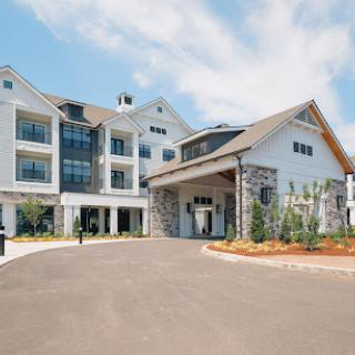 A modern building entrance with a stylish facade and landscaped surroundings.