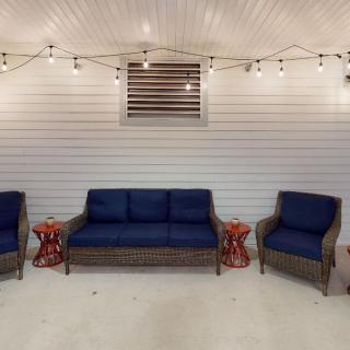 A cozy patio setup with navy blue cushioned seating and decorative string lights.
