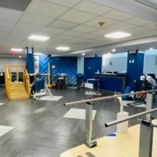 A spacious rehabilitation center with various exercise and therapy equipment.